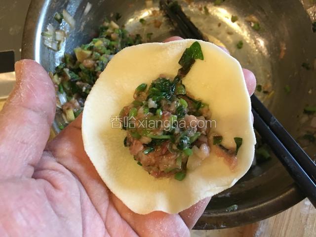 取一个饺子皮，放入适量的苋菜馅儿。