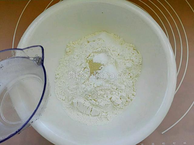 称重面粉放入盆中，倒入酵母，泡打粉干粉拌匀，用温水和成面团，水温不能超过40度。