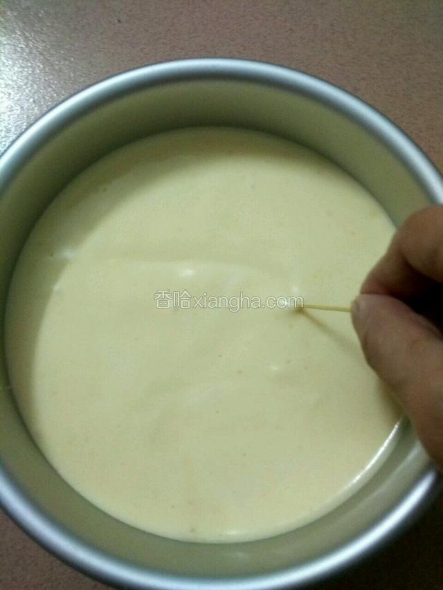 倒入六寸的蛋糕模具里，提起模具震两三次震出大气泡，如果表面还有很多气泡就用牙签以‘Z’字画出气泡