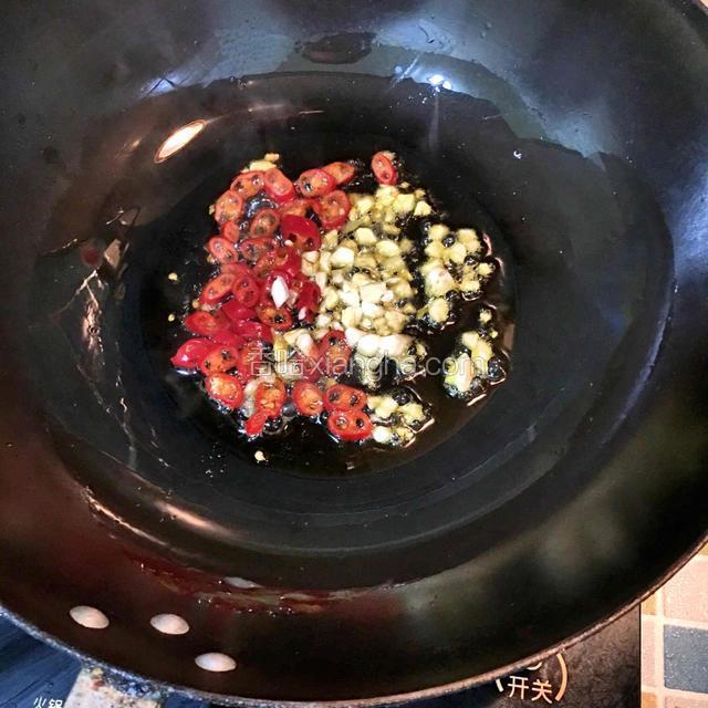 起锅热油，倒入大蒜子、红辣椒圈煸炒出香味