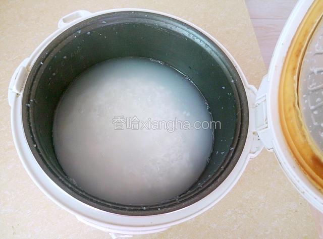 将米饭用清水冲洗抓散，加入1000ml的热开水煲煮40分钟。