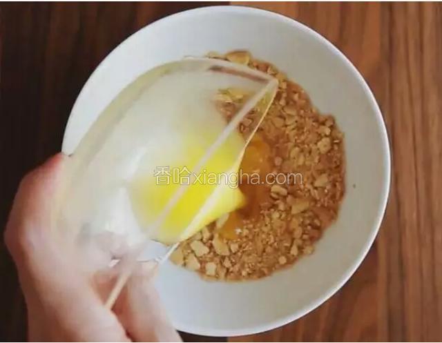 饼干装袋，用擀面杖压成沙粒状，倒入碗中，加黄油，搅拌均匀。
