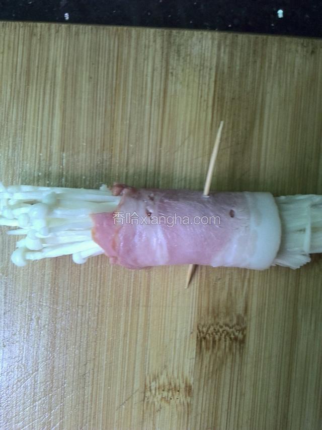 取一段培根，上面放适量金针菇卷起来，接口处朝下，用牙签固定起来。