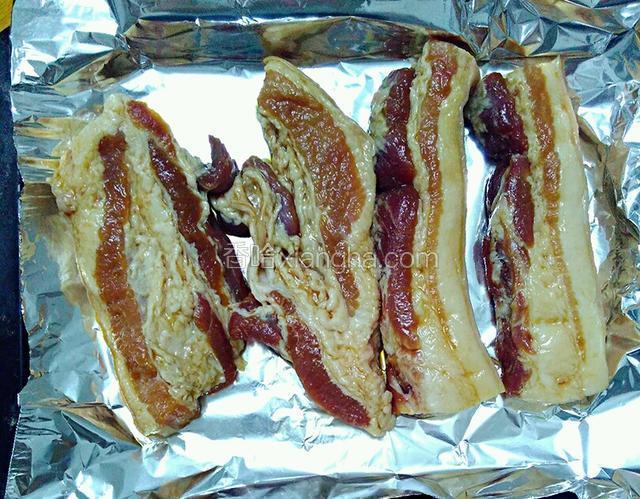 把淹好的肉晾干水分后摆入铺好锡纸的烤盘中