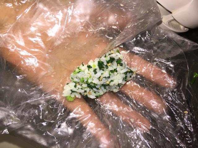 取出适量的米饭用保鲜膜包着，做成饭团