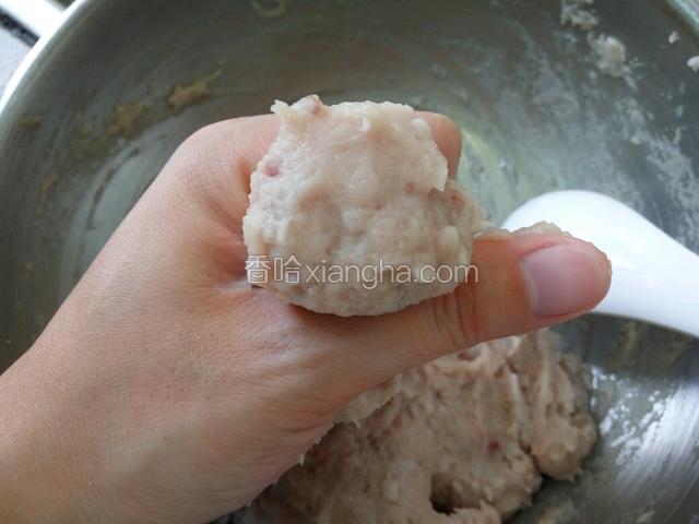 锅内放冷水备用。左手虎口挤出鱼丸（我挤得特别大，都赶上猪肉丸了……）