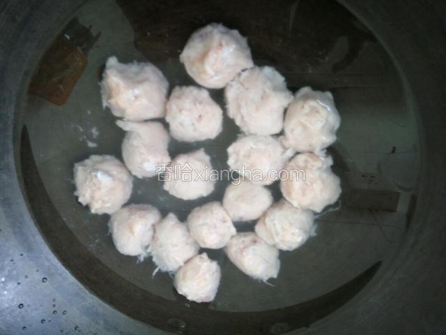 用勺子把鱼丸舀进锅里