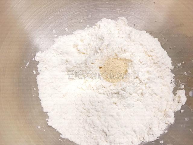 把高筋面粉均匀的铺在步骤一的材料上。中间挖个小坑，放入酵母。厨师机启动和面档，15分钟。