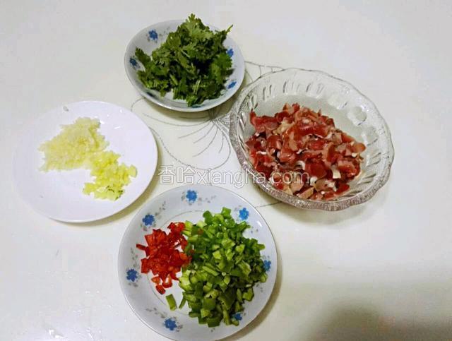准备材料如下:鸡胗洗净切丁；姜、蒜、青椒、红椒分别切粒；香菜切段。