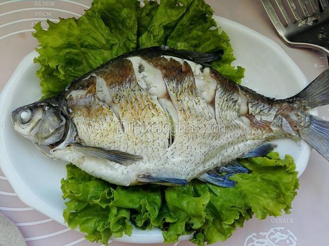 生菜洗净放盘底，小心把蒸熟鱼移倒生菜上