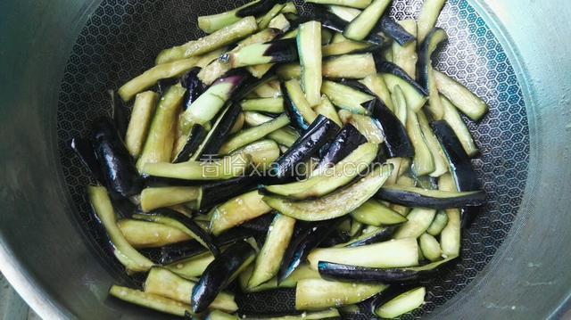 坐锅加油7成热后，下入腌制好的茄条煸炒至软后，出锅备用。