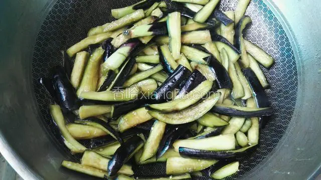 坐锅加油7成热后，下入腌制好的茄条煸炒至软后，出锅备用。