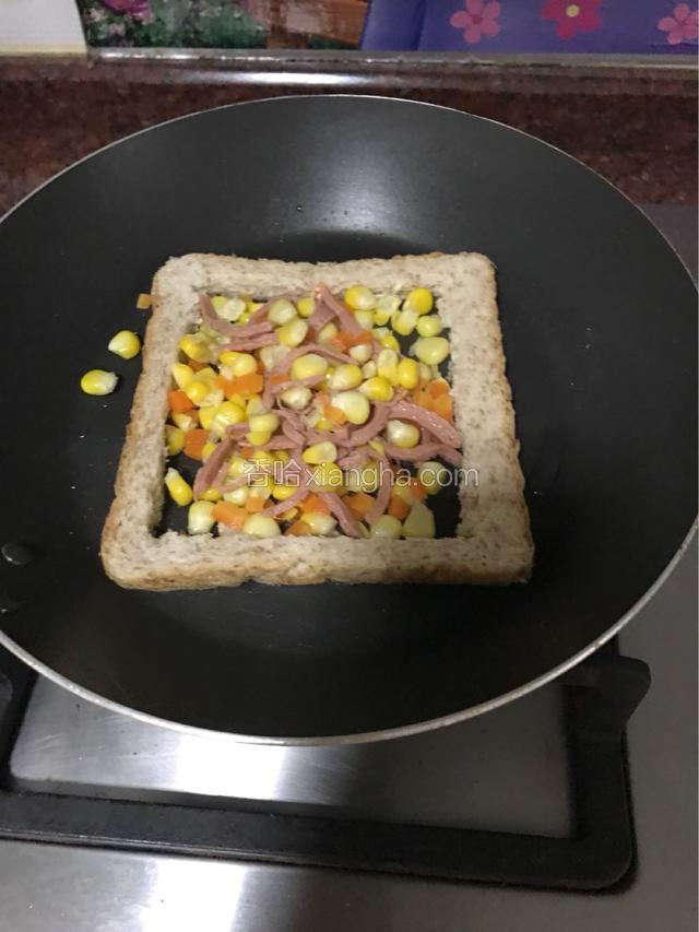 把用水煮熟的肠仔丝、玉米粒、红萝卜粒、放入面包框