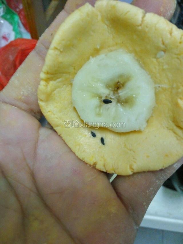 抓面团剂子压扁捏薄，放入一个香蕉片