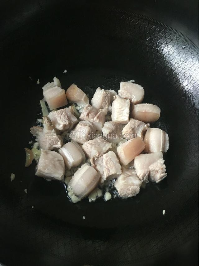 锅中倒入少许油，放入老姜，大蒜爆香，再倒入洗净的五花肉大火翻炒