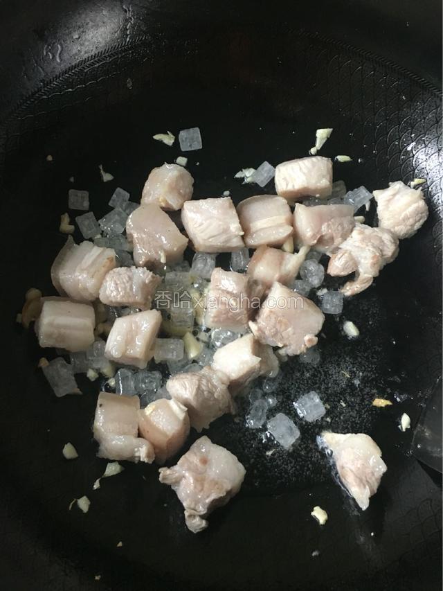 等五花肉炒到微微变色，放适量冰糖小火炒至冰糖融化，依次倒入料酒，生抽，老抽大火翻炒