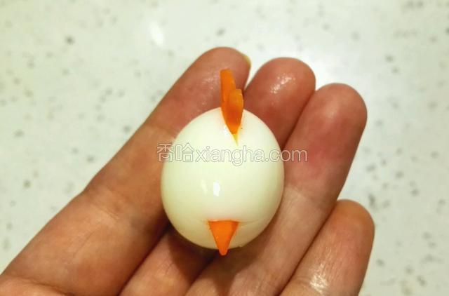 把鹌鹑蛋尖头朝上，用水果刀轻轻竖着划一刀3MM深，把胡萝卜Y字插入，再在蛋的1/3处横着划一刀，把三角插入。如图