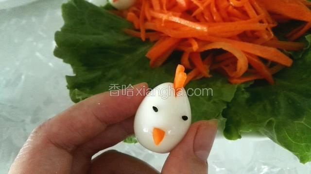 用筷子蘸水，把黑芝麻粘在鹌鹑蛋中上部，小鸟就完成了。