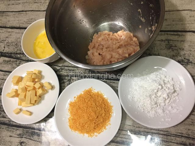 准备好所有的材料：芝士去掉保护膜，4片叠放一起切成小粒，鸡蛋打散，面包糠、淀粉分别放入盘中