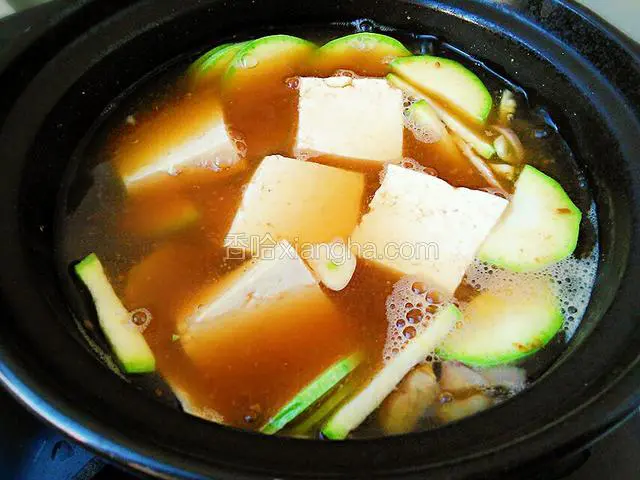 放入豆腐西葫芦，小洋葱丝，姜蒜片继续煮