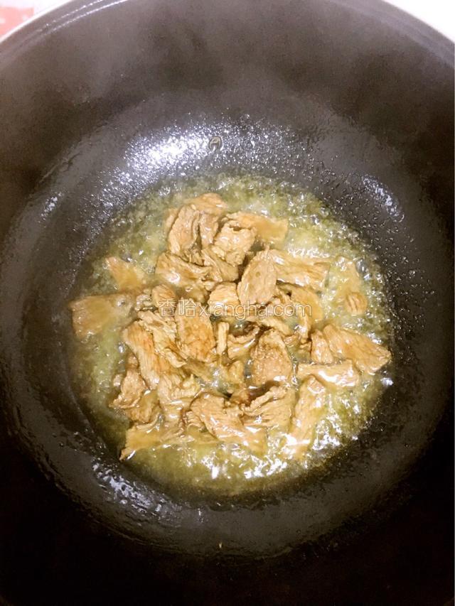 锅里放入花生油，油热放入牛肉翻炒，倒入料酒去腥，炒制没有水分。