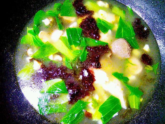把青菜和紫菜也放入锅里，调入盐，鸡精和十三香，即可盛入容器里食用。
