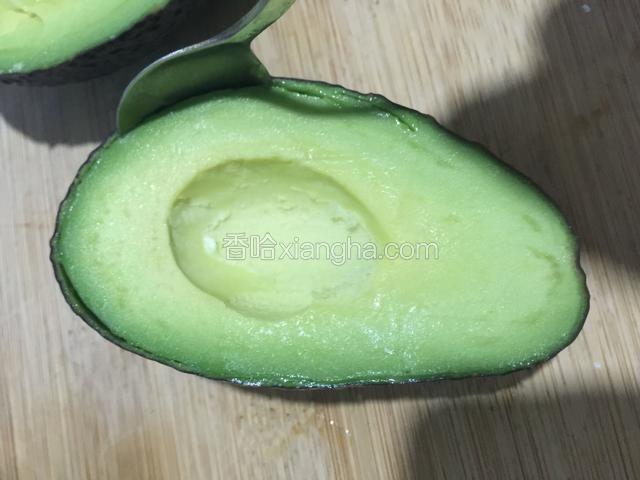 用勺子延着皮划一圈，去掉外皮，取出果肉