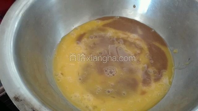 用手动打蛋器将蛋黄打散，加入咖啡液