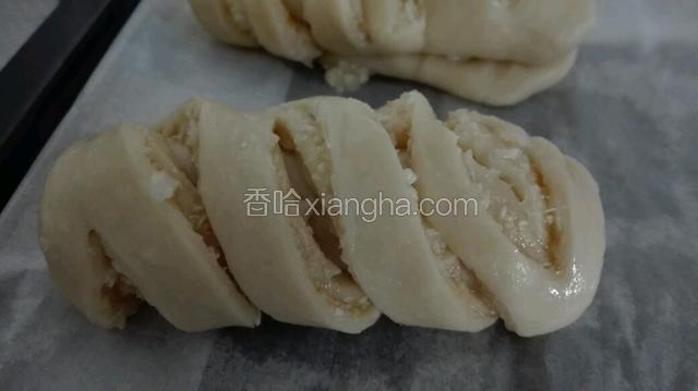 剪好后放在烤盘中。烤盘上面要放吸油纸。然后放在烤箱中，启动发酵功能，三十分钟。