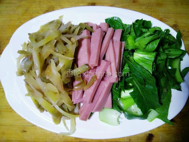 把榨菜和火腿切成细长条，青菜切段。