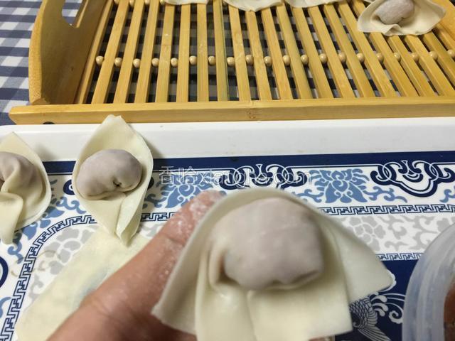 将云吞皮的两个角叠加在一起，捏紧就行，如果云吞皮比较干，可用筷子沾点水在一个角上，防止云吞皮松开。