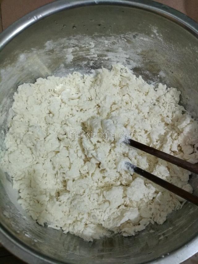 面粉倒入盆里，加入热水，用筷子搅拌成棉絮状