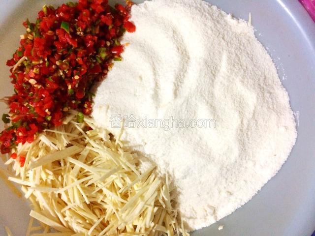 取一个大的容器倒入碾碎好的米粉、芋头丝、辣椒、少许盐