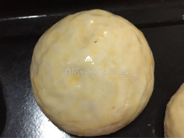 面团发酵松软，原有的两倍大了，预热烤箱170度上下火，再打散开鸡蛋，面包表面刷上蛋液