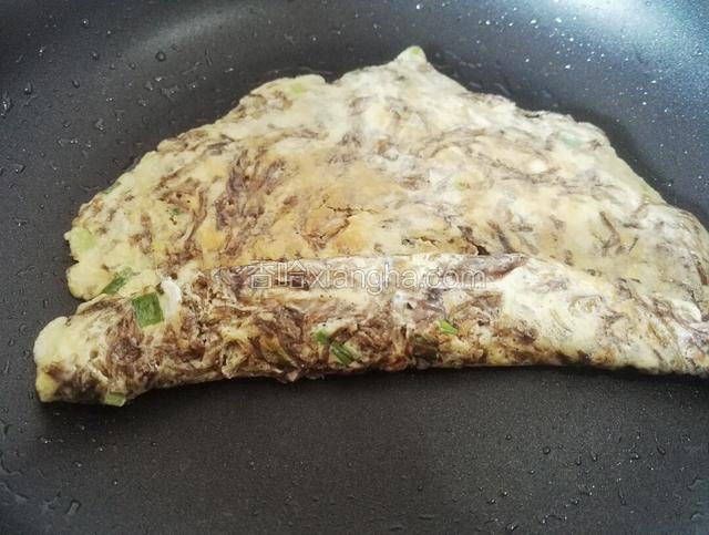 将煎好的紫菜蛋饼朝一个方向卷起来