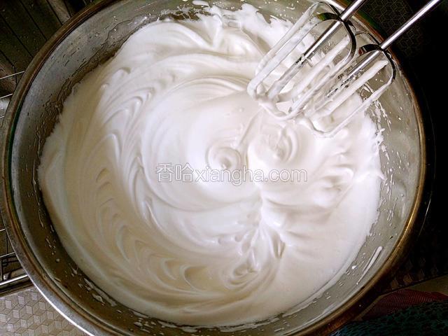 然后分三次把白糖加入到蛋清中，搅打至硬性发泡，提起打蛋头有小尖角，打发蛋清的详细步骤可参见我电饭煲蛋糕，轻乳酪蛋糕等其它蛋糕谱子，此处不再赘述