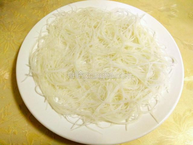 泡软的粉丝用剪刀剪短，然后平铺在盘子上