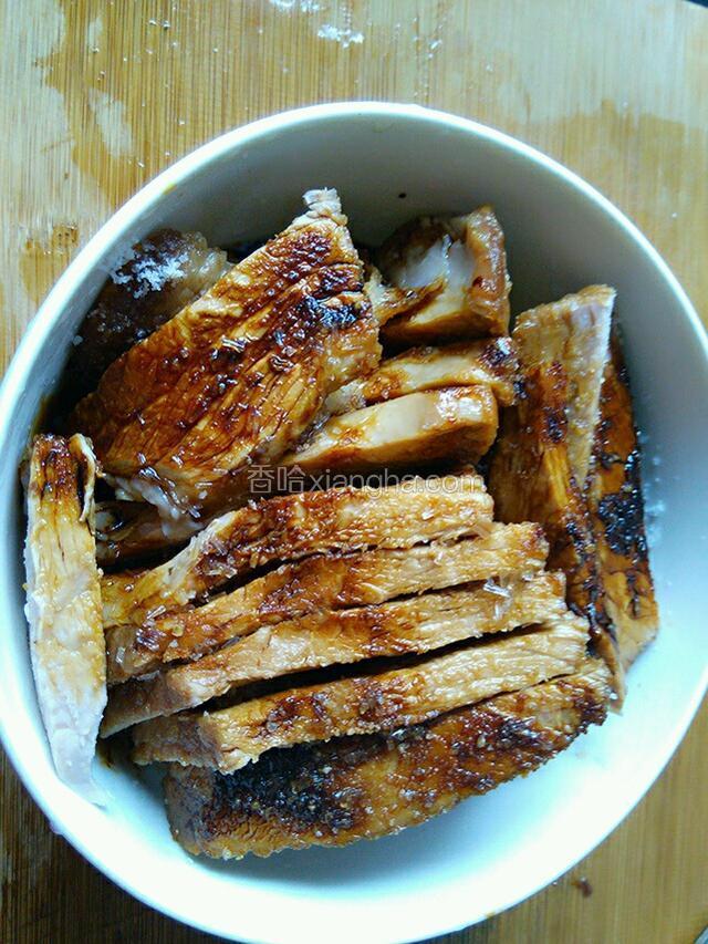 取一个大碗，把切好的肉肉皮朝下摆入碗中，淋上适量生抽、老抽，加少一点点盐，少许料酒。