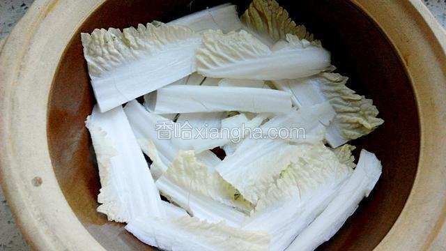 将白菜帮铺在砂锅底部，锅边也放些