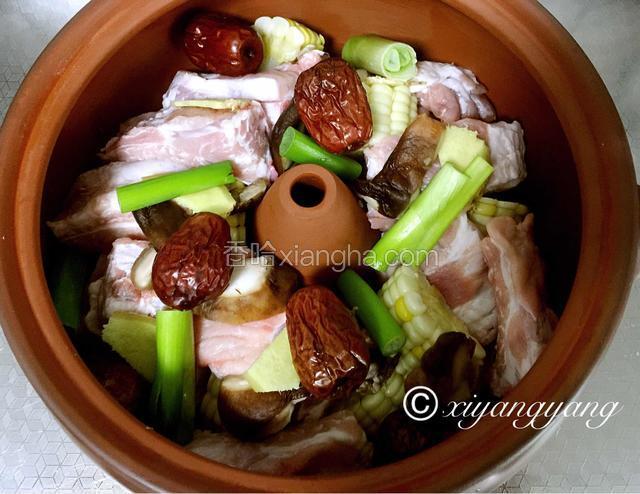 将鲜香菇片码在汽锅底部，依次码进排骨，玉米，将大枣、枸杞、葱段、姜片码在最上面，加入适量盐、料酒。
