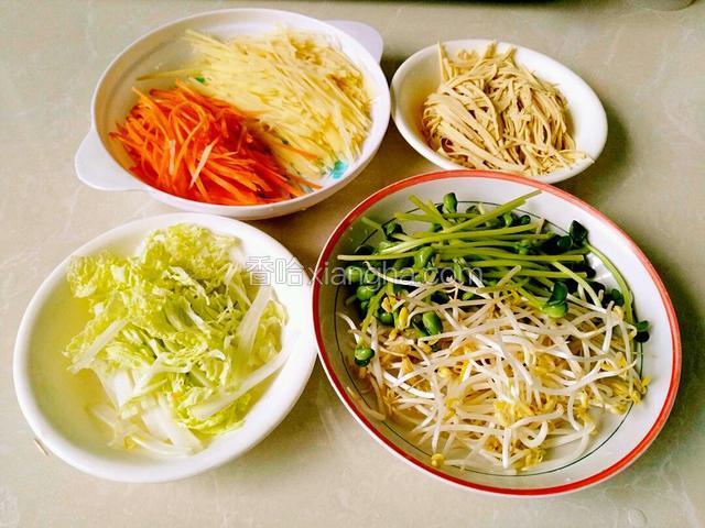 准备几种蔬菜，土豆切丝，洗去淀粉水。胡萝卜切丝，白菜切丝，豆腐皮切丝。绿豆芽，豆苗洗净备用。