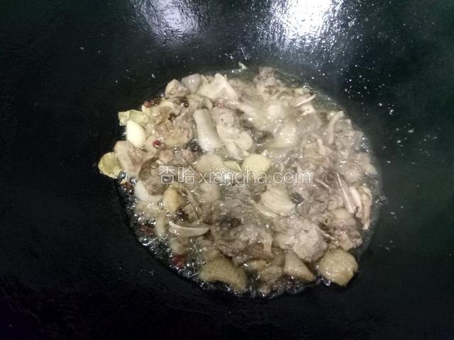 下入鸭肉，爆干水分。锅中温度最高时，放入料酒去腥，加点白糖提味。