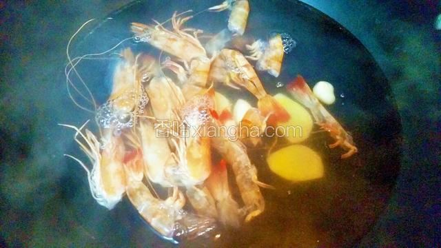 水沸下食油、米酒、虾头和虾壳，盖上盖子水再沸小火煮20分钟