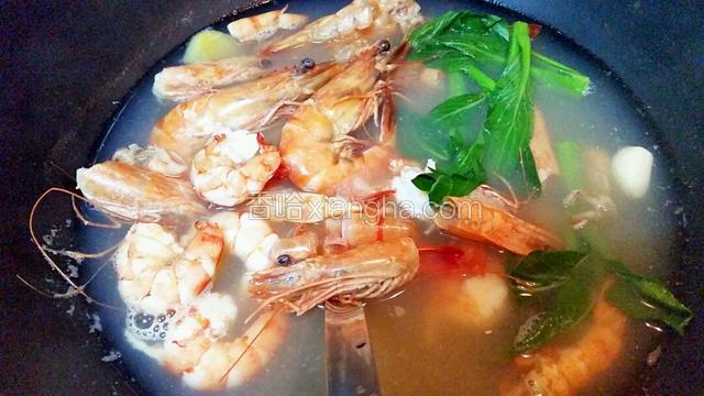 虾头虾壳汤煮好后，汤里先下2只完整的大虾，再下虾仁和青菜，全部材料煮熟下盐和豉油调味，熄火捞起虾头和虾壳