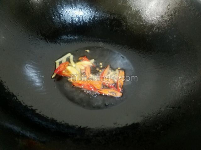 油五成热时放入红椒和姜炝锅。