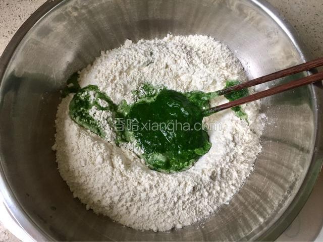 将菠菜泥分次少量加入面粉中。