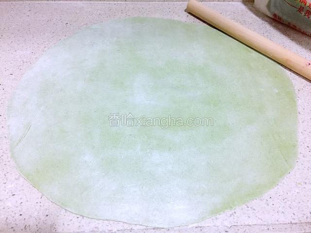 案板上撒上干面粉，取出面团擀成厚薄均匀的圆形薄片，再在面片上均匀地撒上干面粉防止粘连。