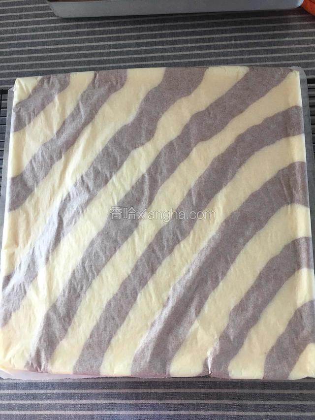 时间到取出蛋糕，取一张干净的油纸放蛋糕上倒扣