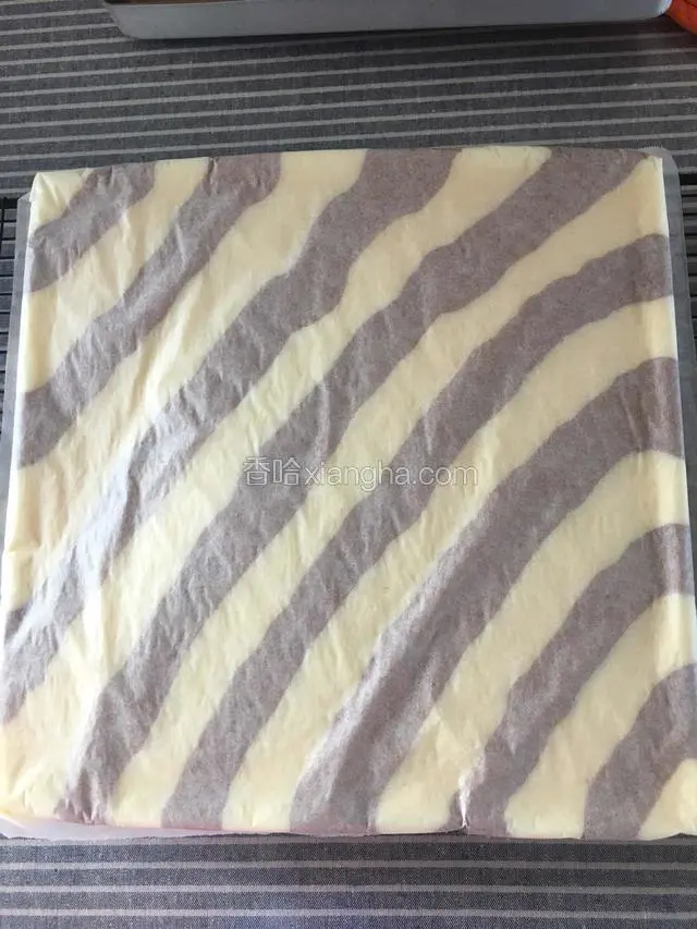 时间到取出蛋糕，取一张干净的油纸放蛋糕上倒扣