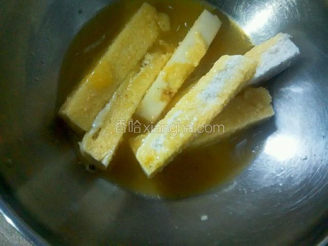 把馒头条迅速裹上液蛋。这个动作得快，以防馒头条泡软。
